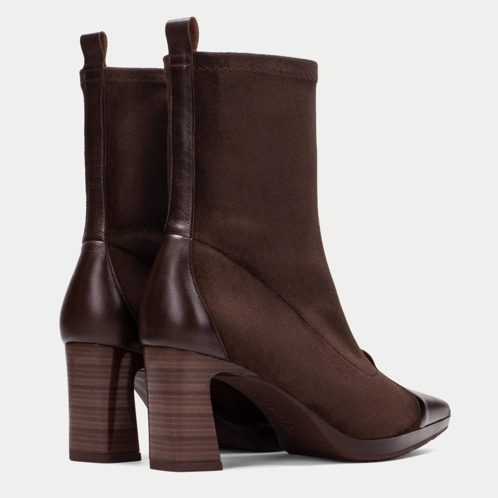 A pair of Hispanitas dark brown ankle boots with a mix of suede and smooth leather panels, featuring a block heel, pointed toe, and front zippers, shown against a light grey background.