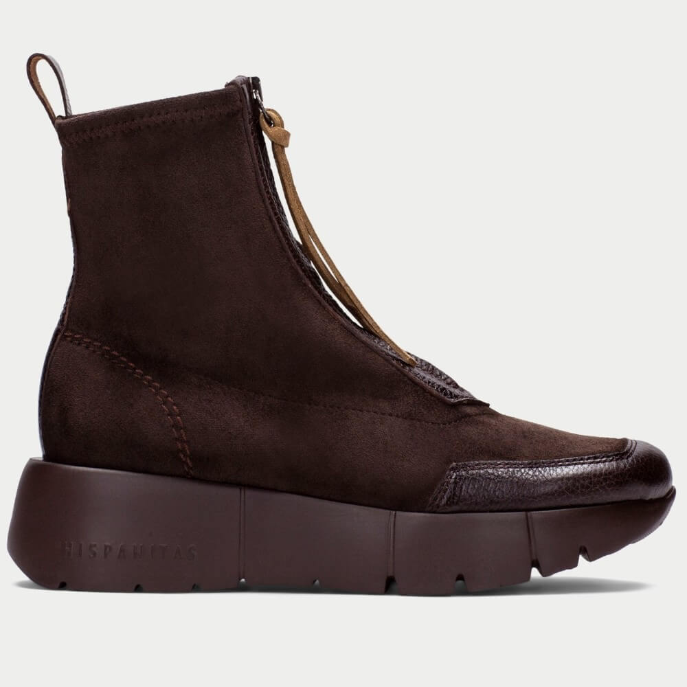 A dark brown ankle boot with a thick platform sole, featuring a textured leather toe cap, a tan zipper pull, and 'HISPANITAS' embossed on the side of the sole, shown against a light gray background.