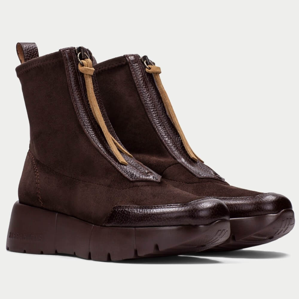 A pair of Hispanitas dark brown ankle boots with textured leather and suede panels, tan zipper pulls, and chunky platform soles, shown against a light gray background.