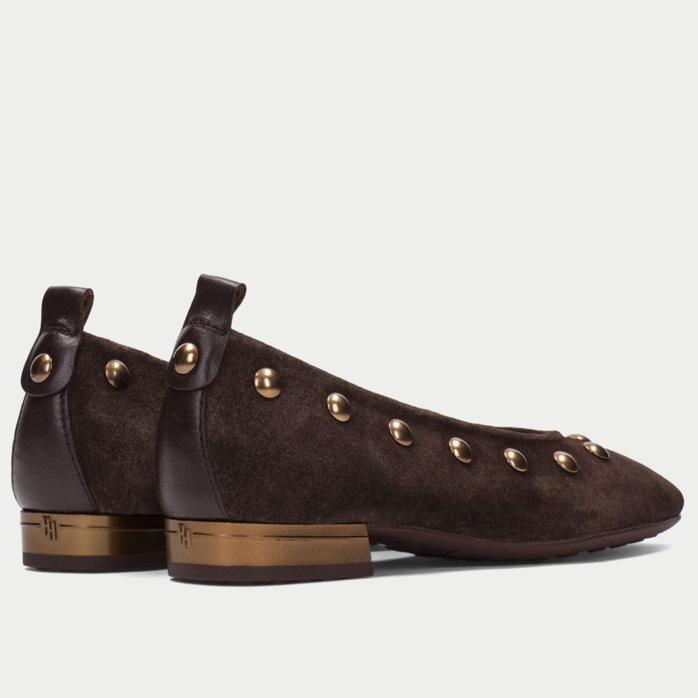 A pair of Hispanitas dark brown suede ballet flats with gold-tone metal studs, shown from a side profile view against a light grey background.