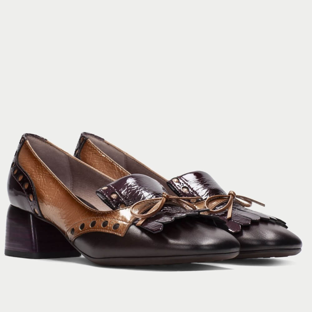 A pair of Hispanitas women's block-heel pumps featuring a colour-blocked design with glossy dark plum leather, tan leather, and silver-tone decorative studs, shown against a light grey background.