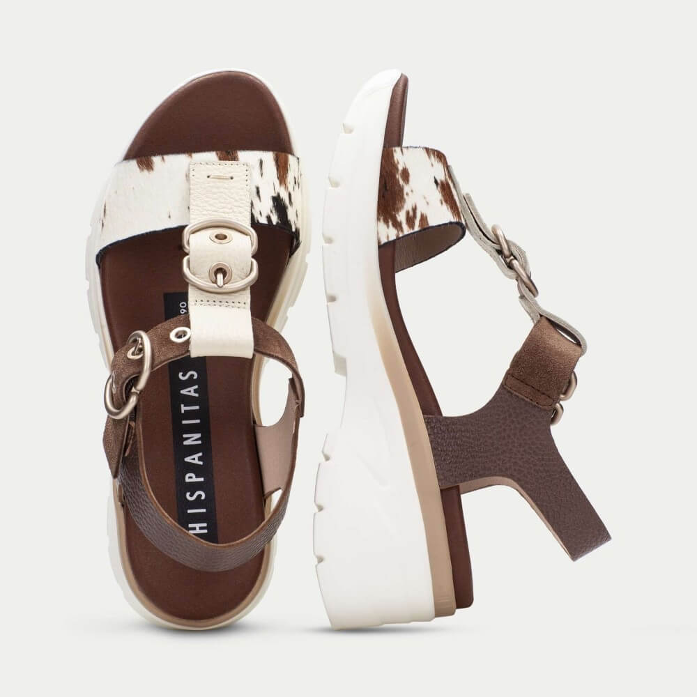 Brown and white sandals with a visible brand logo on a light gray background