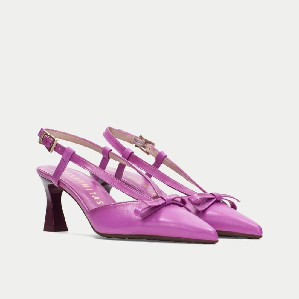 Pair of pink high-heeled shoes with a bow on a white background
