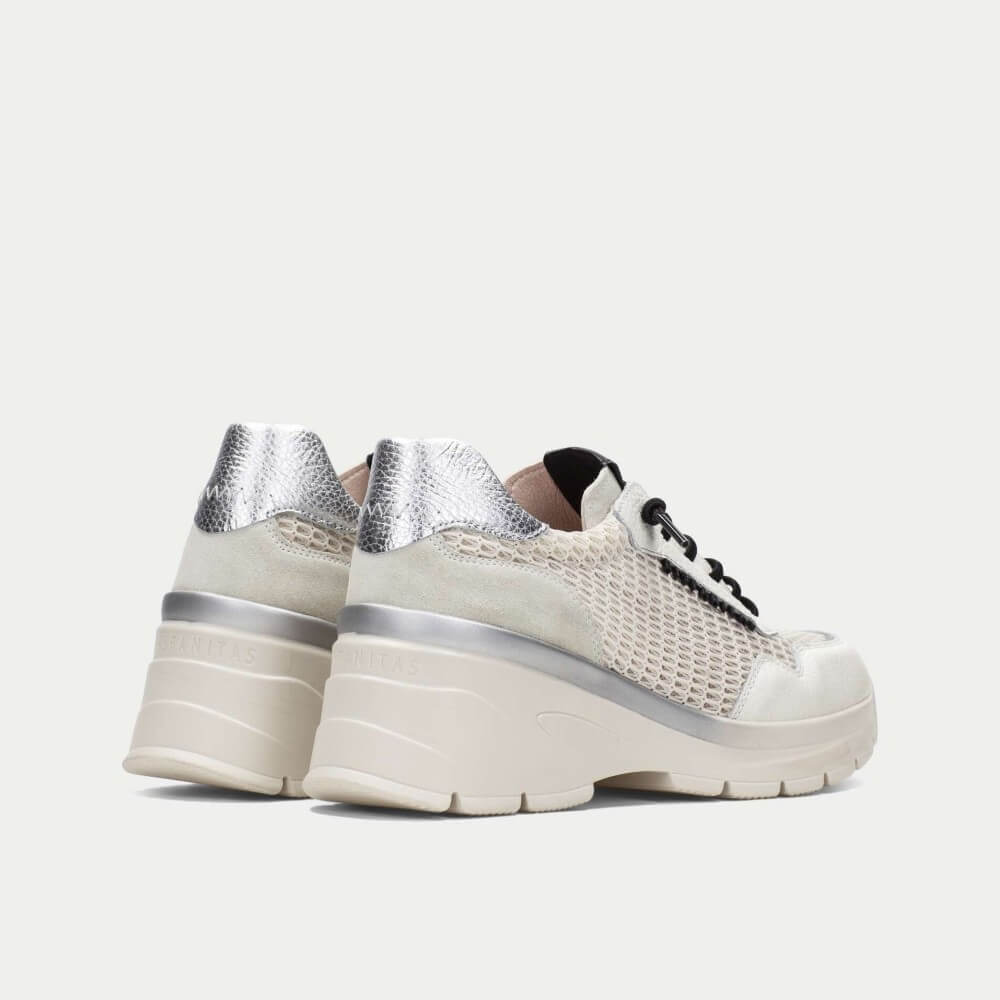 White sneakers with silver accents on a white background
