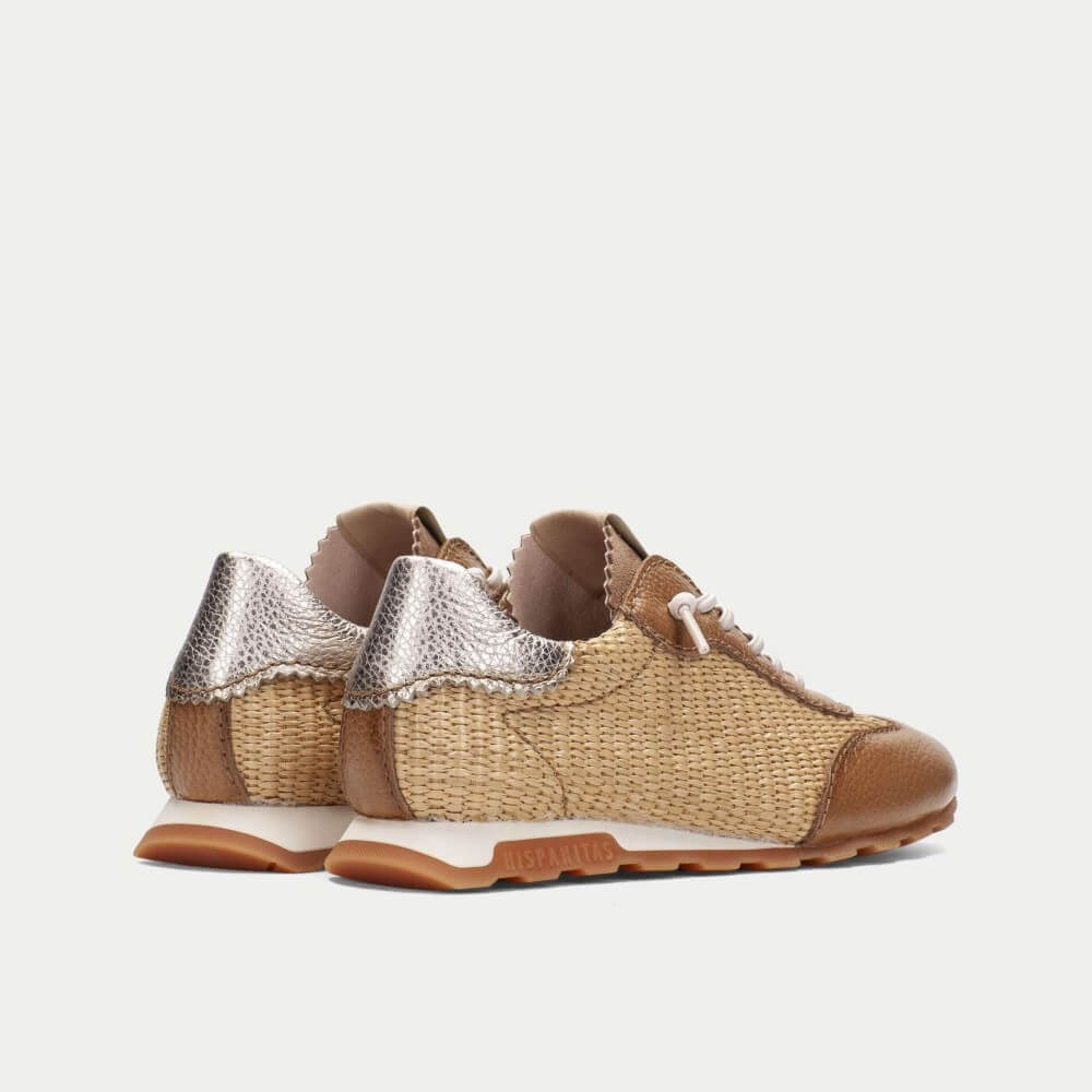 Pair of woven sneakers with metallic accents on a white background
