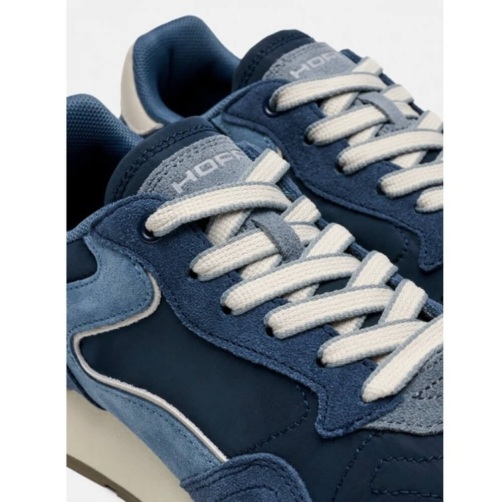 Close-up of a blue Hoff sneaker with white laces on a white background