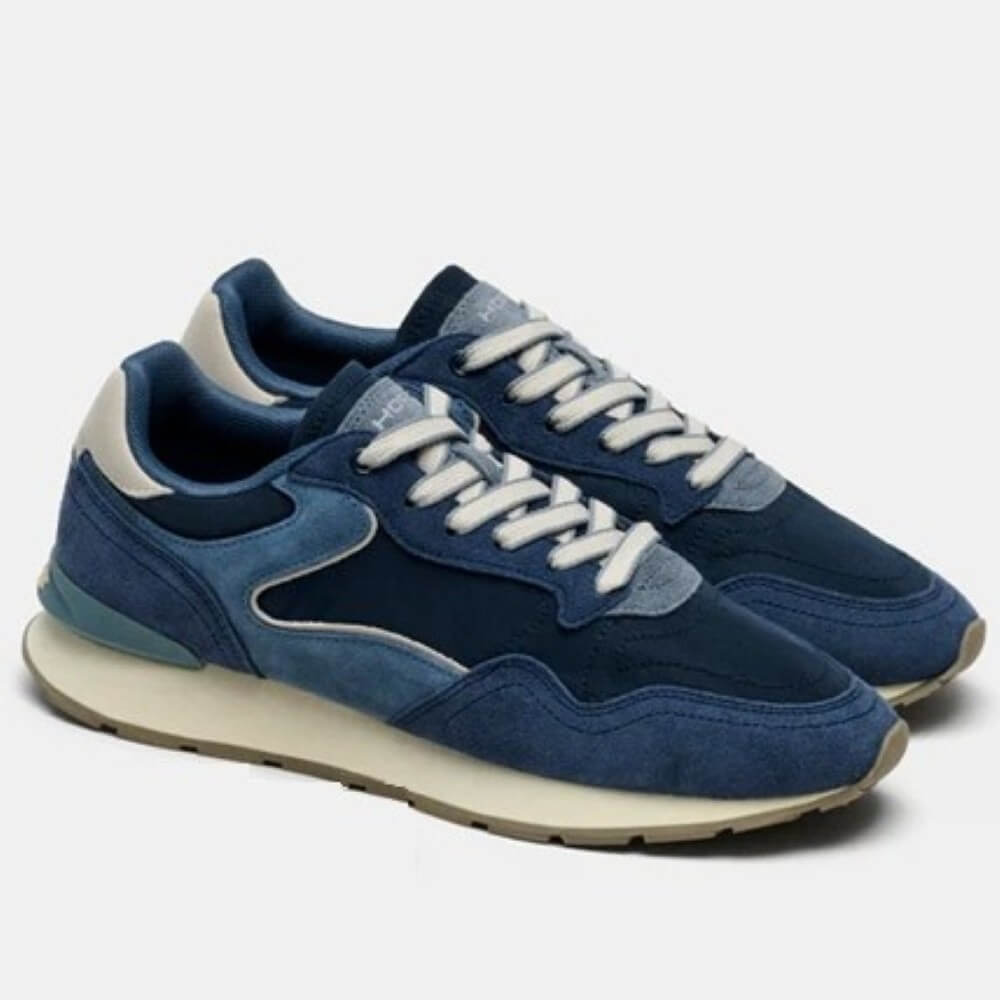 Blue sneakers with white laces on a light gray background