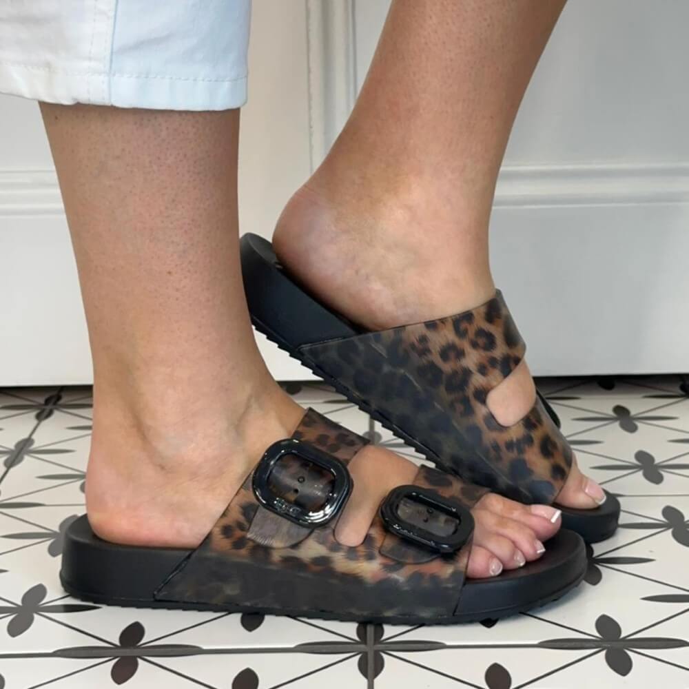 Igor Leopard print sandals with black buckles worn on a light surface