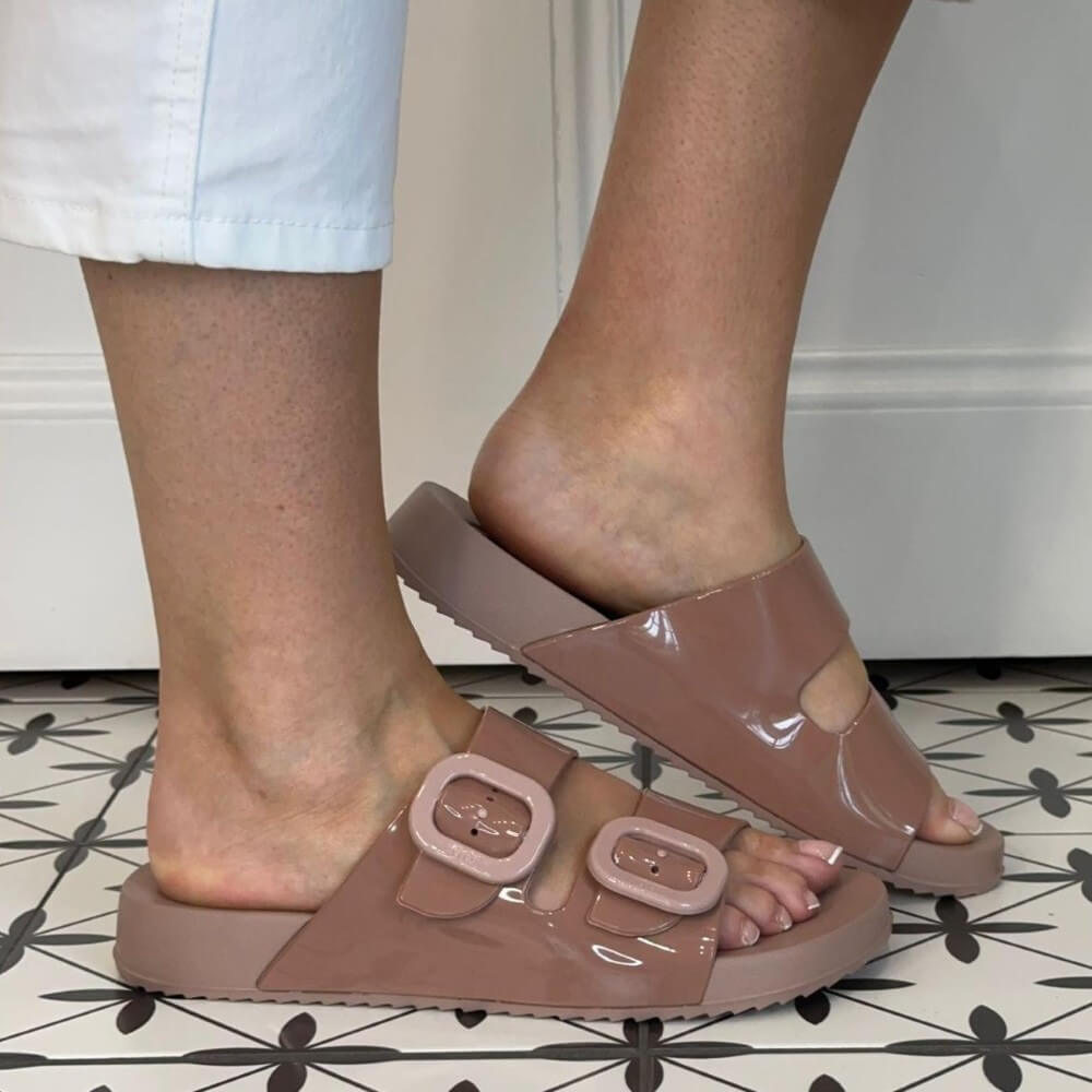 Igor Rose Pink sandals worn with a patterned floor and white wall background