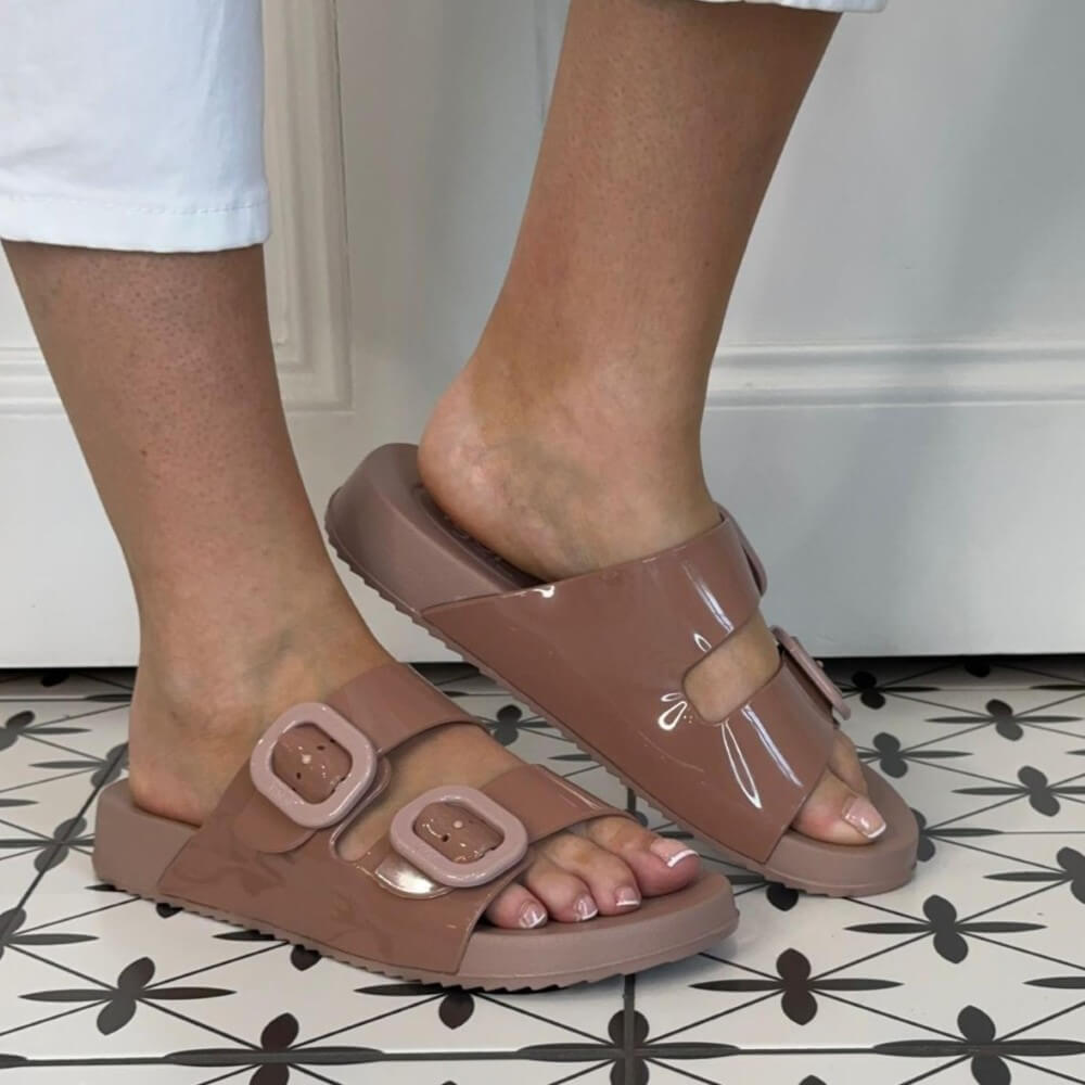 Igor Rose Pink sandals worn with a patterned floor and white wall background