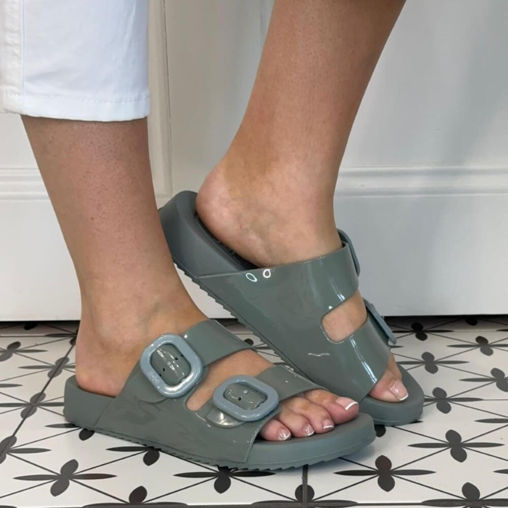 Person wearing Igor Verde Green sandals with buckles on a tiled floor.