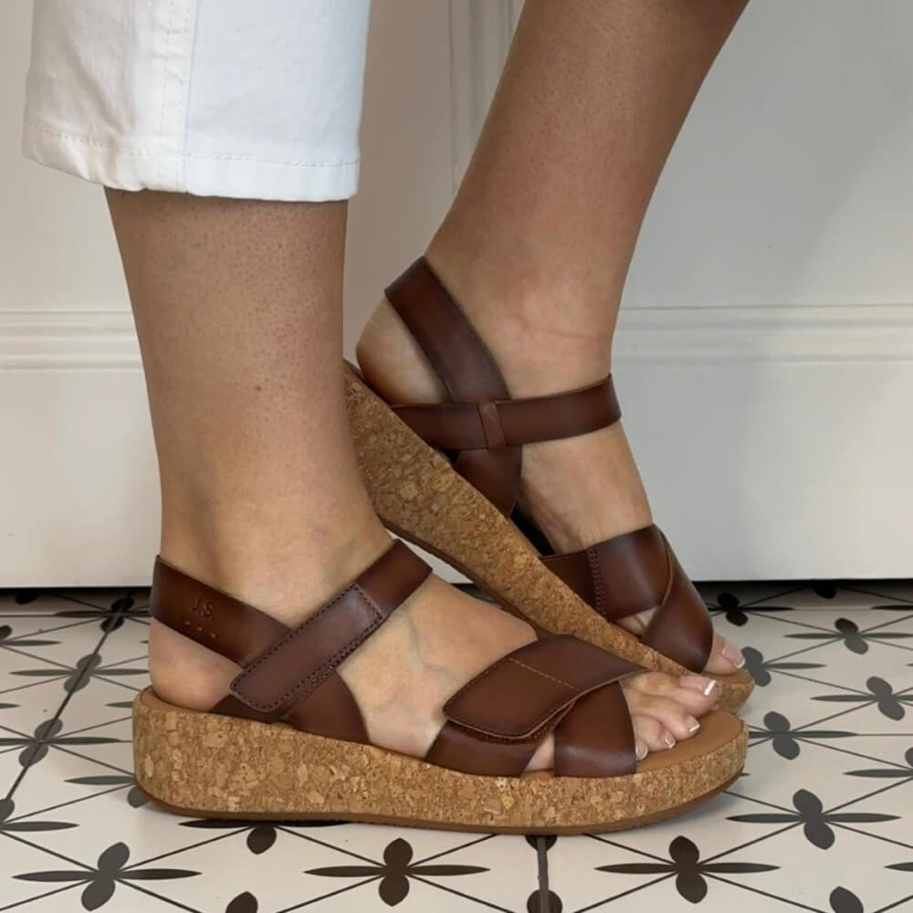 Josef Seibel Brown leather sandals worn by a person on a patterned floor.