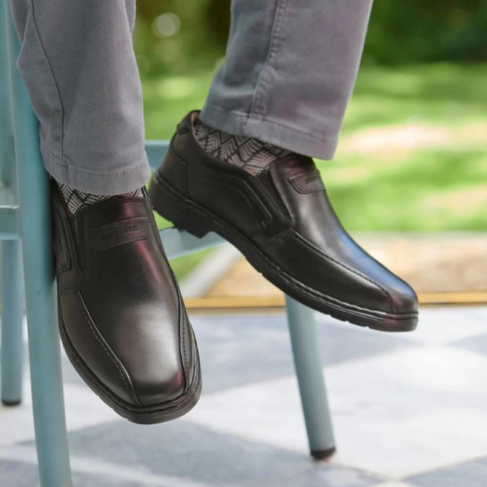 Person wearing black shoes and gray pants sitting on a chair  Black leather shoe  Josef Seibel ALASTAIR 03 Extra Wide-BLACK Leather