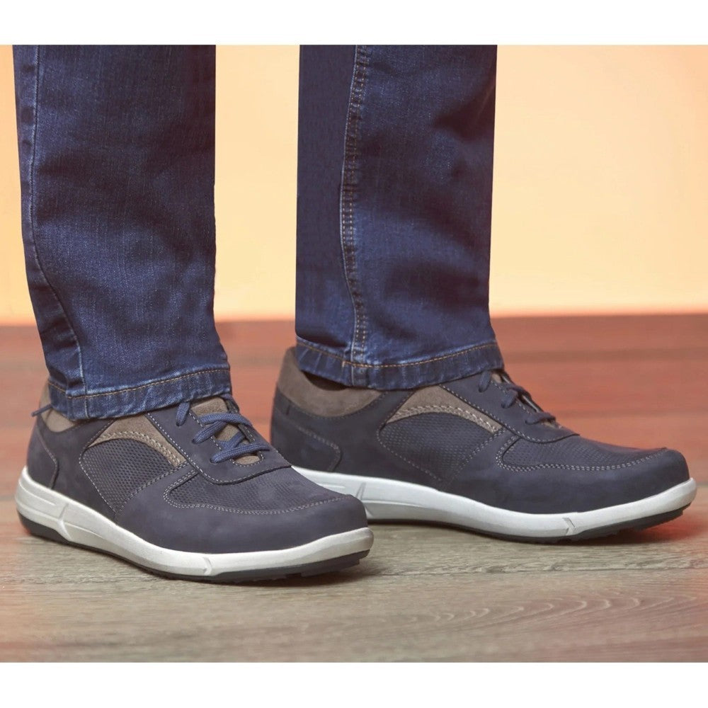 Josef Seibel Navy blue casual shoes worn with blue jeans on a wooden floor.