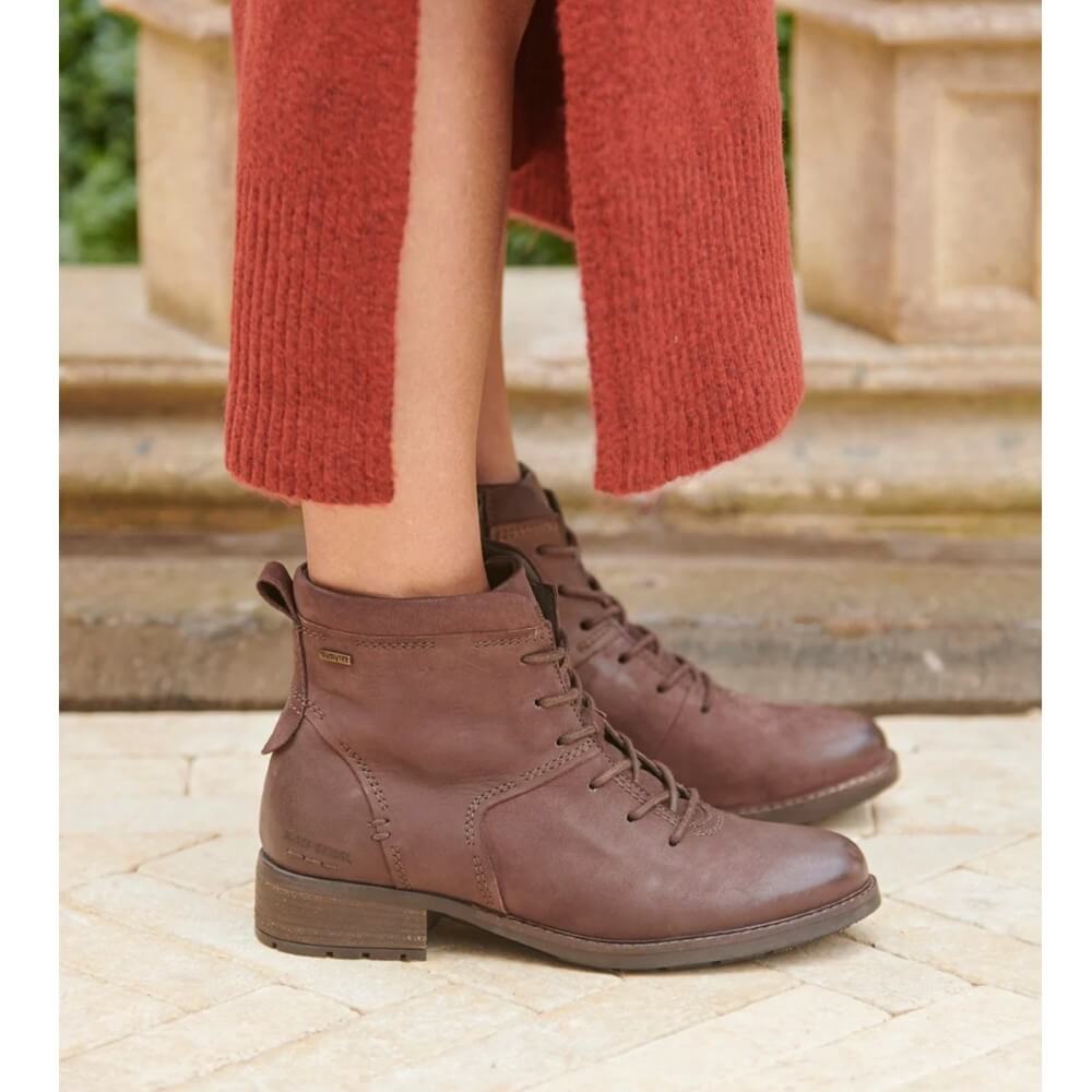 Person wearing Josef Seibel Kate 52 Waterproof Moro Brown Leather Ankle Boots with a red wool dress