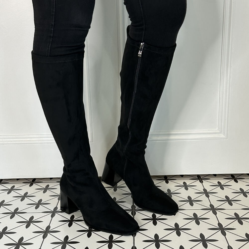 Black knee-high boots worn with black pants on a patterned floor. LODI A-HALBOR Knee High Boot Black