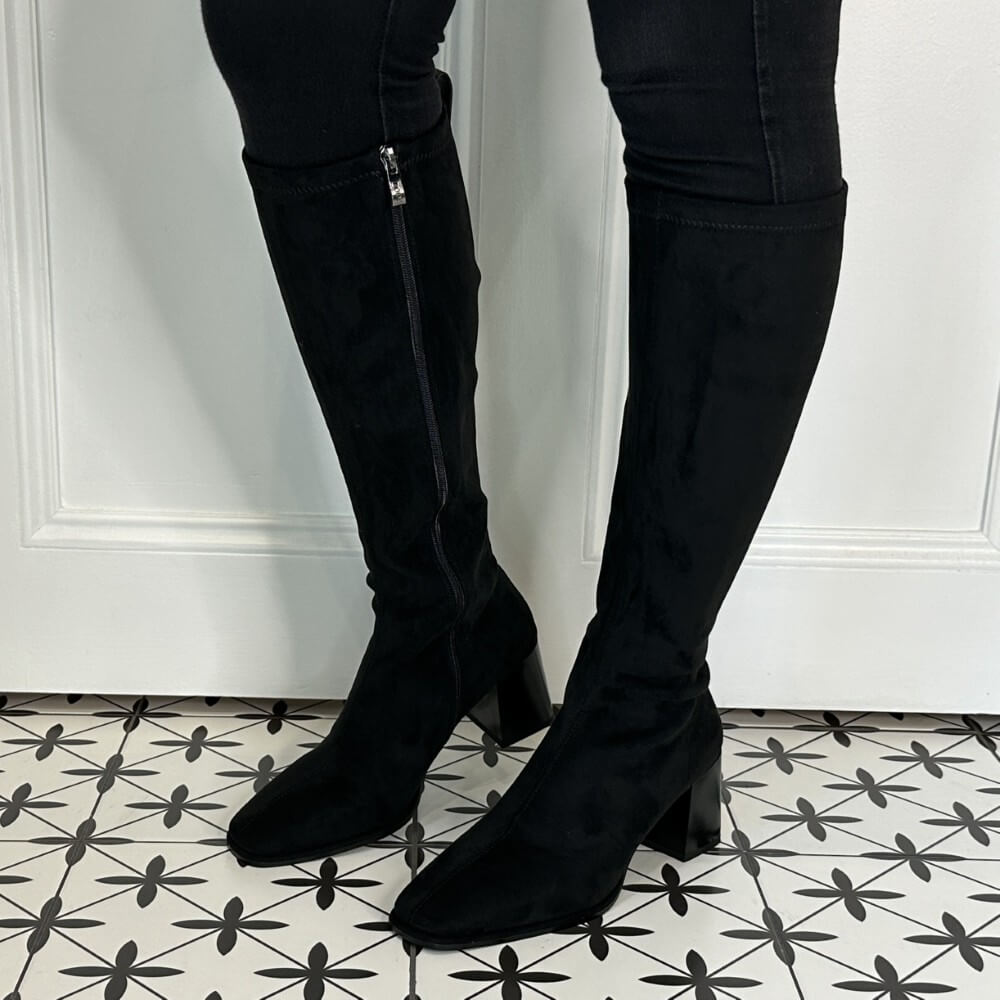 Black knee-high boots worn with black pants on a patterned floor. LODI A-HALBOR Knee High Boot Black