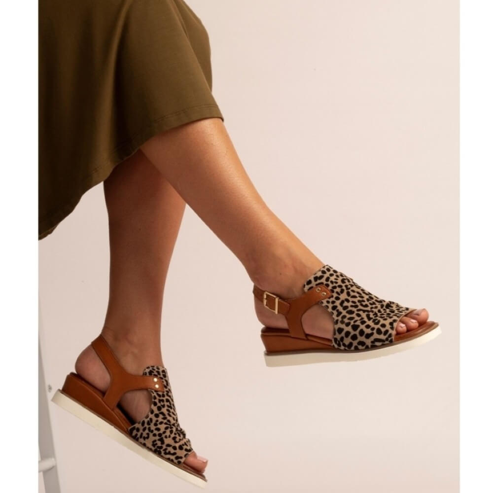 Lunar Leopard print sandals worn with a green dress on a plain background