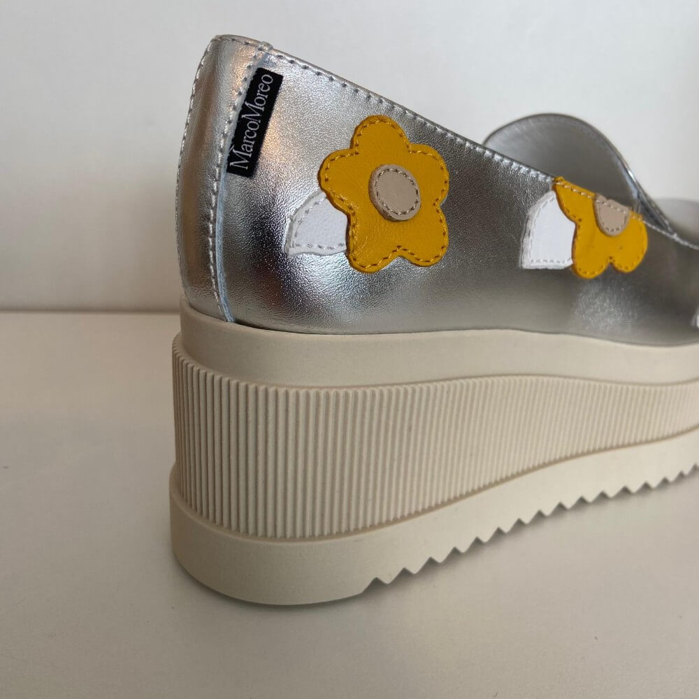 Marco Moreo Silver platform shoe with yellow flower designs on a white background