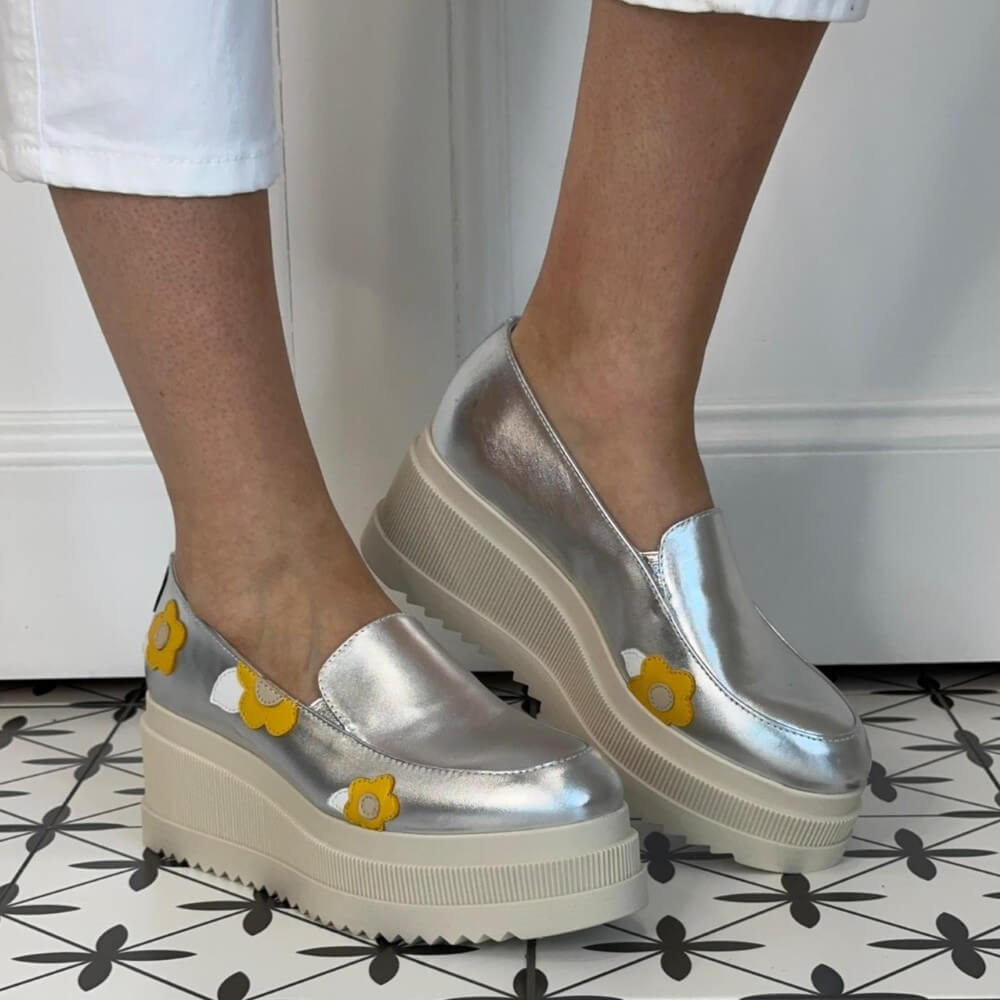 Marco Moreo Silver platform shoes with yellow flower designs worn indoors on a patterned floor.