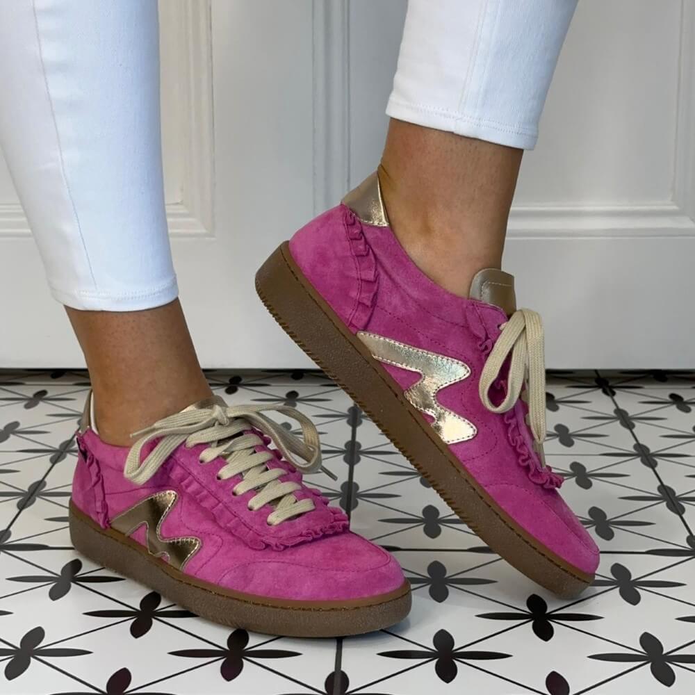 Marco Moreo Pink sneakers with gold star details worn indoors on a patterned floor.