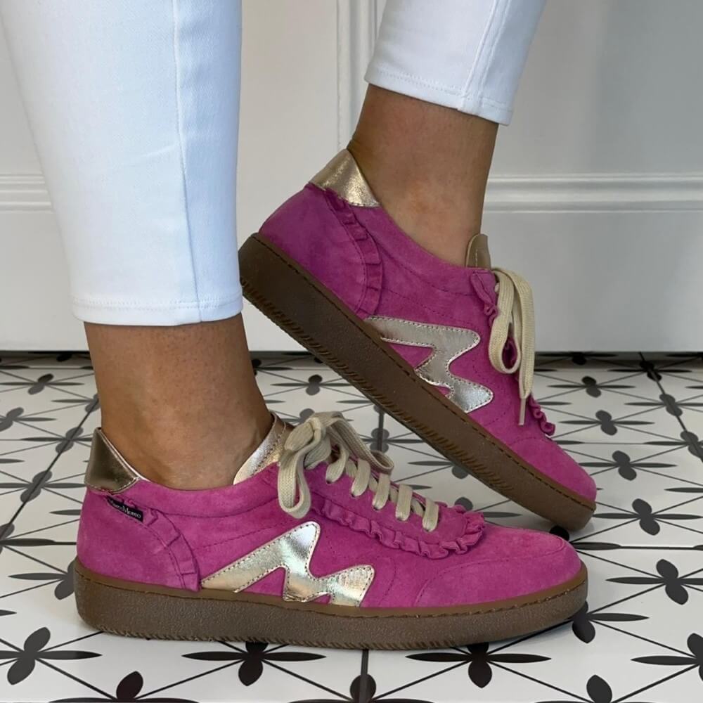 Marco Moreo Pink sneakers with gold star details worn indoors on a patterned floor.