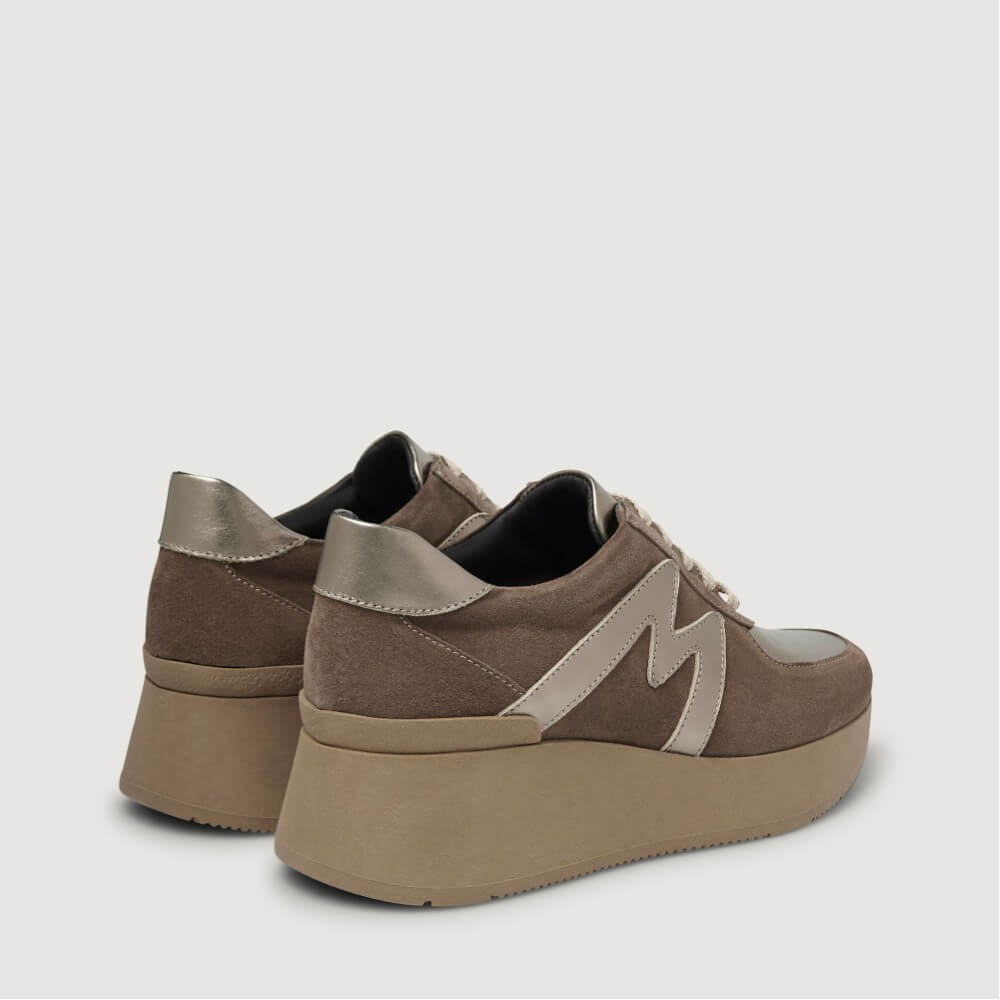 A pair of Marco Moreo platform sneakers in brown suede and beige synthetic material, featuring metallic silver heel caps and a large silver 'M' logo on the side, set against a light gray background.