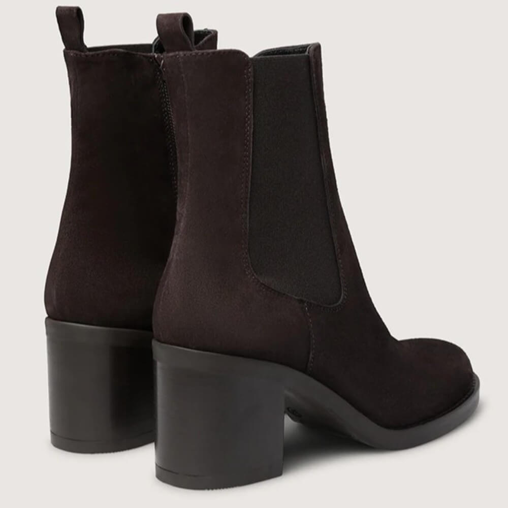 Pair of dark brown ankle boots with block heels on a light gray background