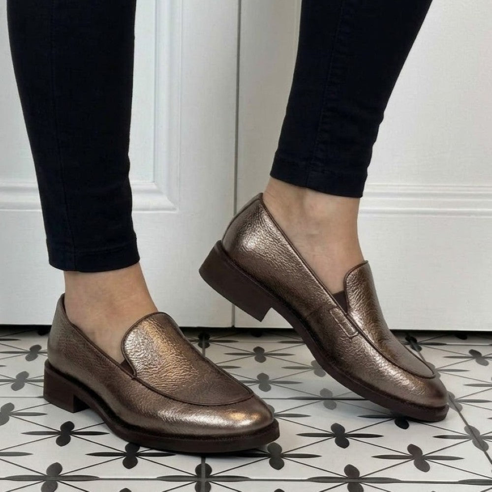 Marco Moreo bronze loafers worn with black jeans on a tiled floor