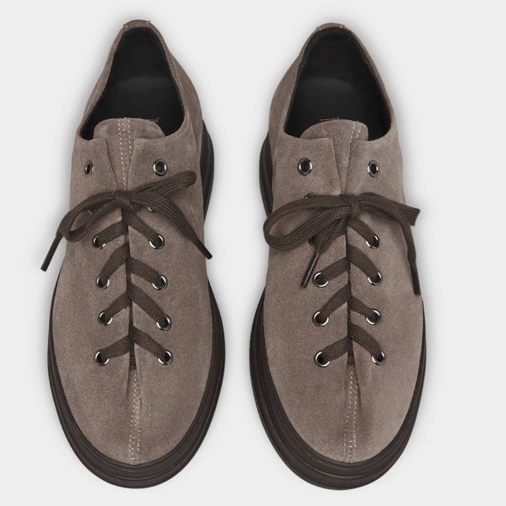 A pair of Marco Moreo taupe-brown suede lace-up shoes with dark brown laces and black soles, shown from a top-down view on a light grey background.