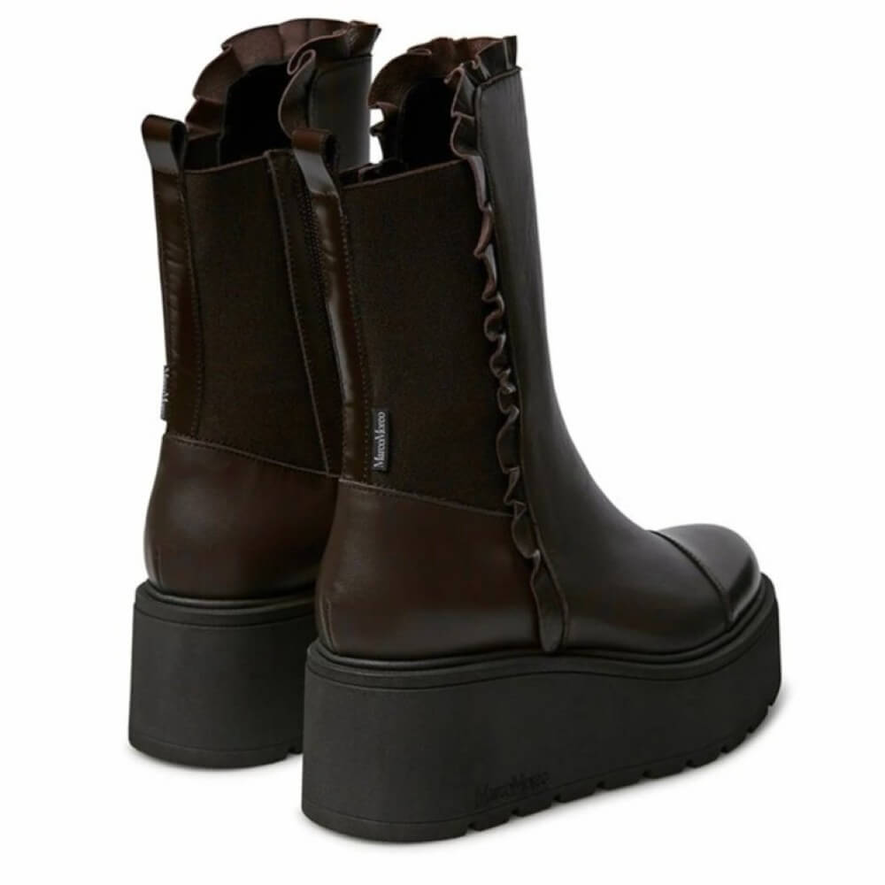 Pair of brown platform boots with ruffled details on a white background