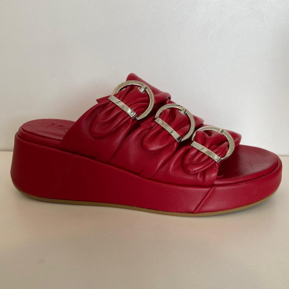 Marco Moreo Red sandal with metallic buckles on a beige surface