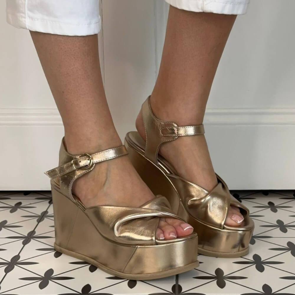 Marco Moreo Gold platform sandals worn on a patterned floor.