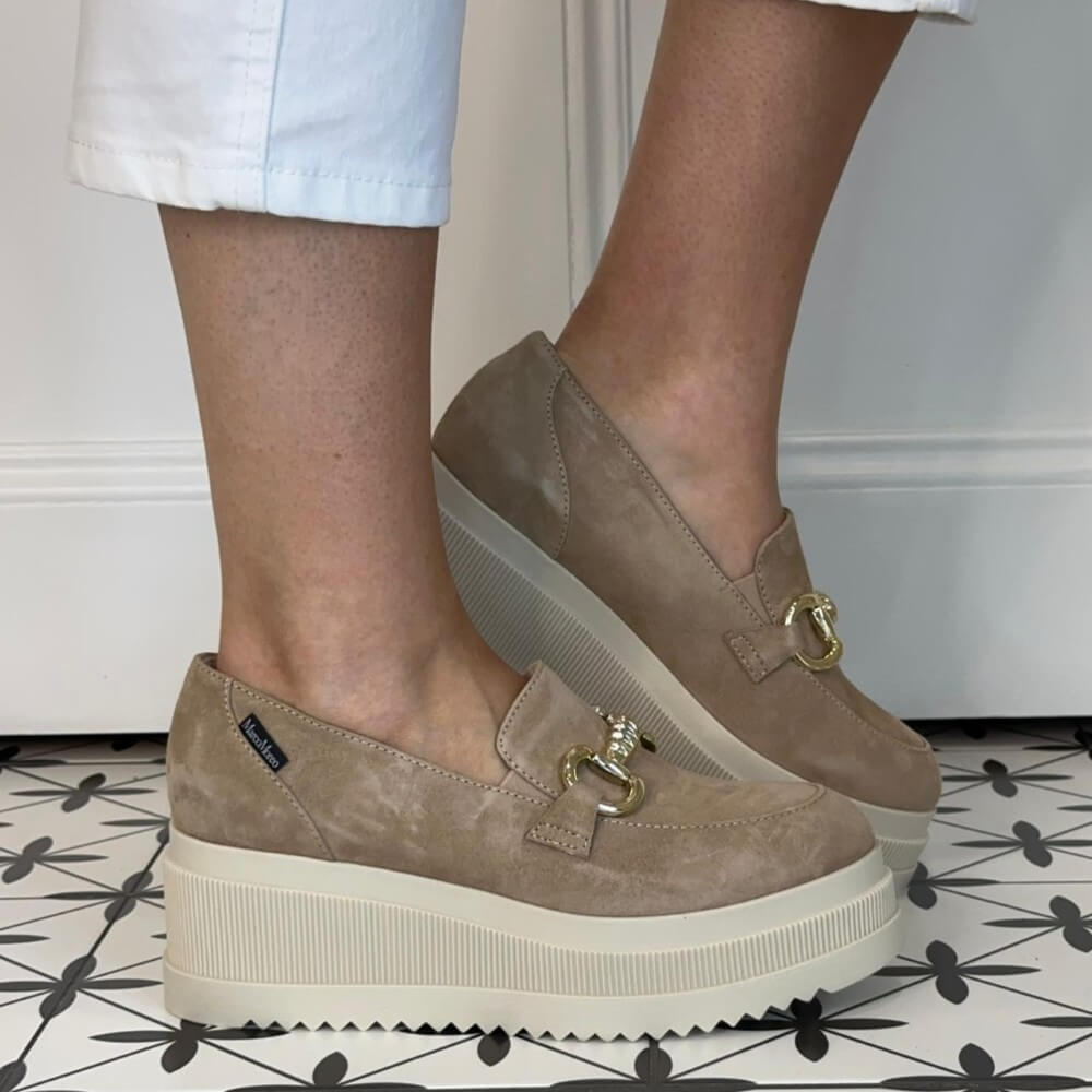 Marco Moreo Beige loafers with gold buckles worn by a person on a patterned floor.
