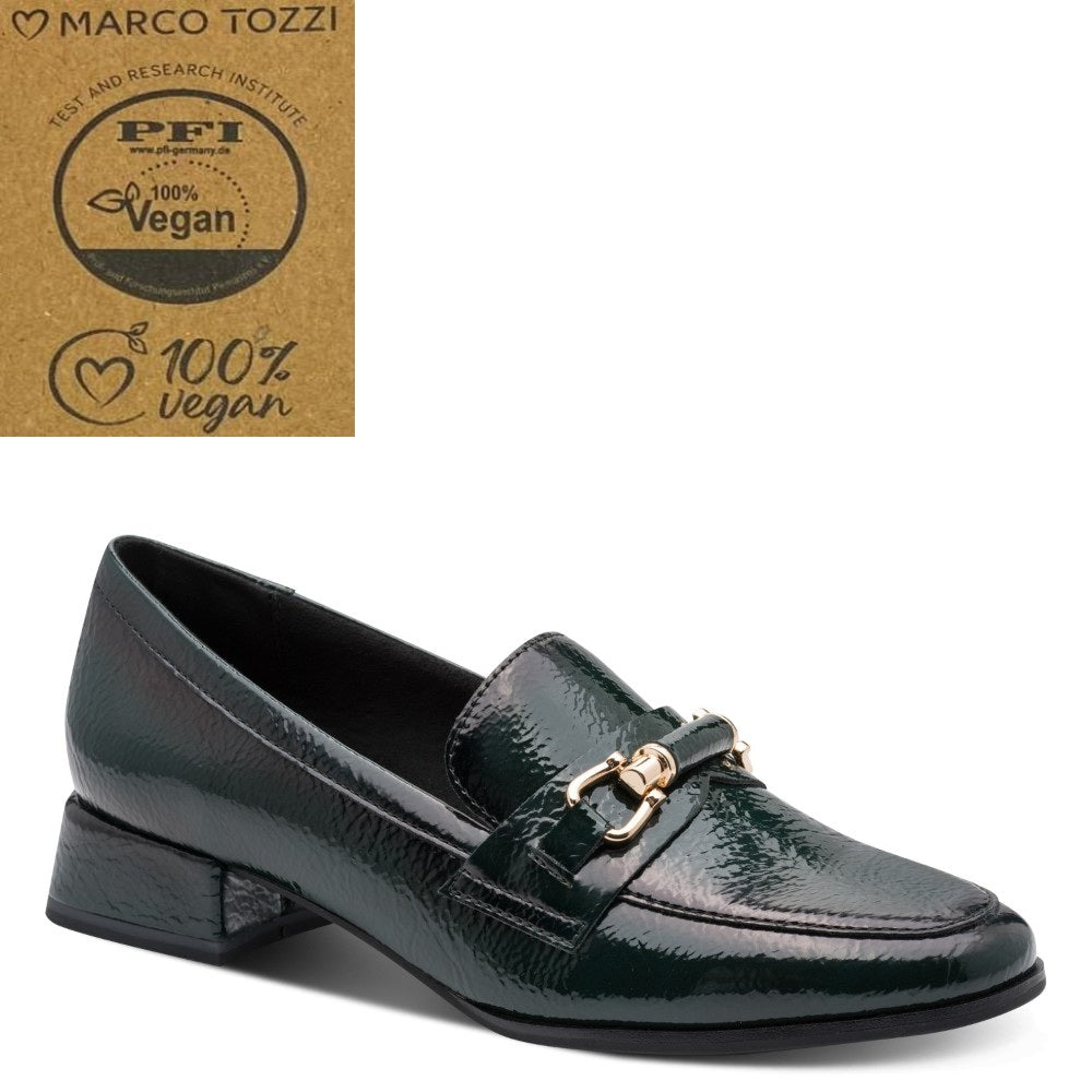 A dark green textured vegan loafer by Marco Tozzi, featuring a gold-tone horse bit detail on the strap. The shoe is displayed on a clean white background with a brown '100% Vegan' certification card from PFI and the Marco Tozzi brand logo in the top-left corner.