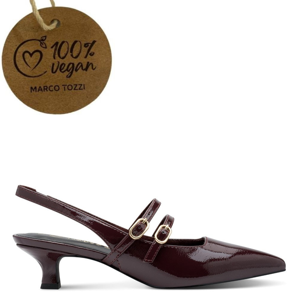 A Marco Tozzi pointed-toe slingback heeled shoe in glossy dark burgundy patent leather with double straps and gold-tone hardware, shown on a white background with a hanging brown paper tag reading 100% vegan MARCO TOZZI.