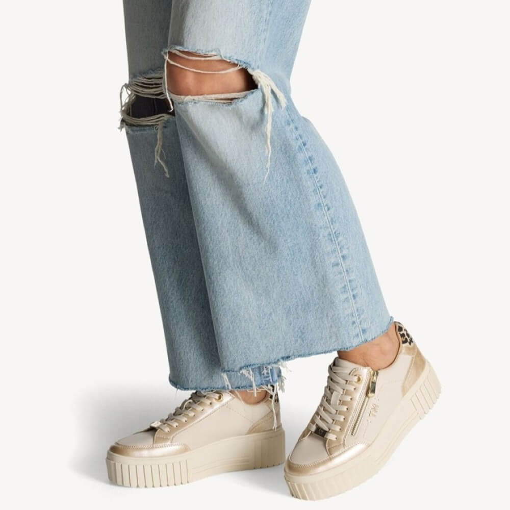 Person wearing ripped light blue jeans and beige sneakers on a white background Marco Tozzi Vegan Platform Sneaker 2-23760-CREAM