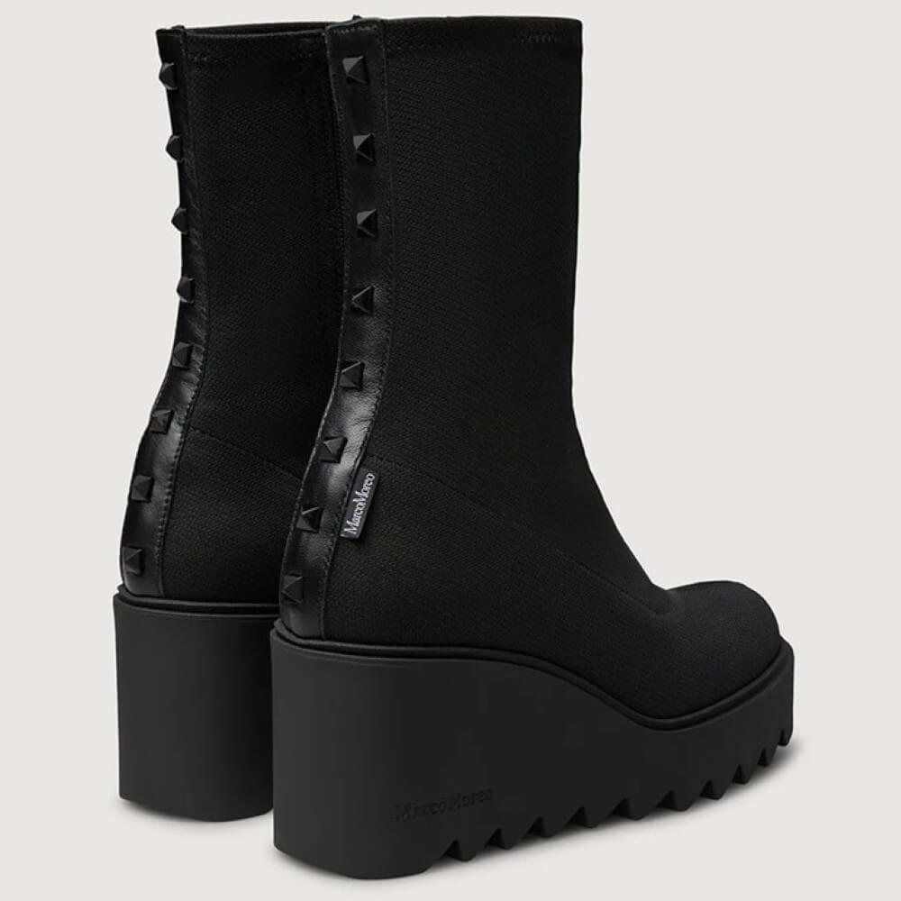 Black platform boots with studded details on a light gray background