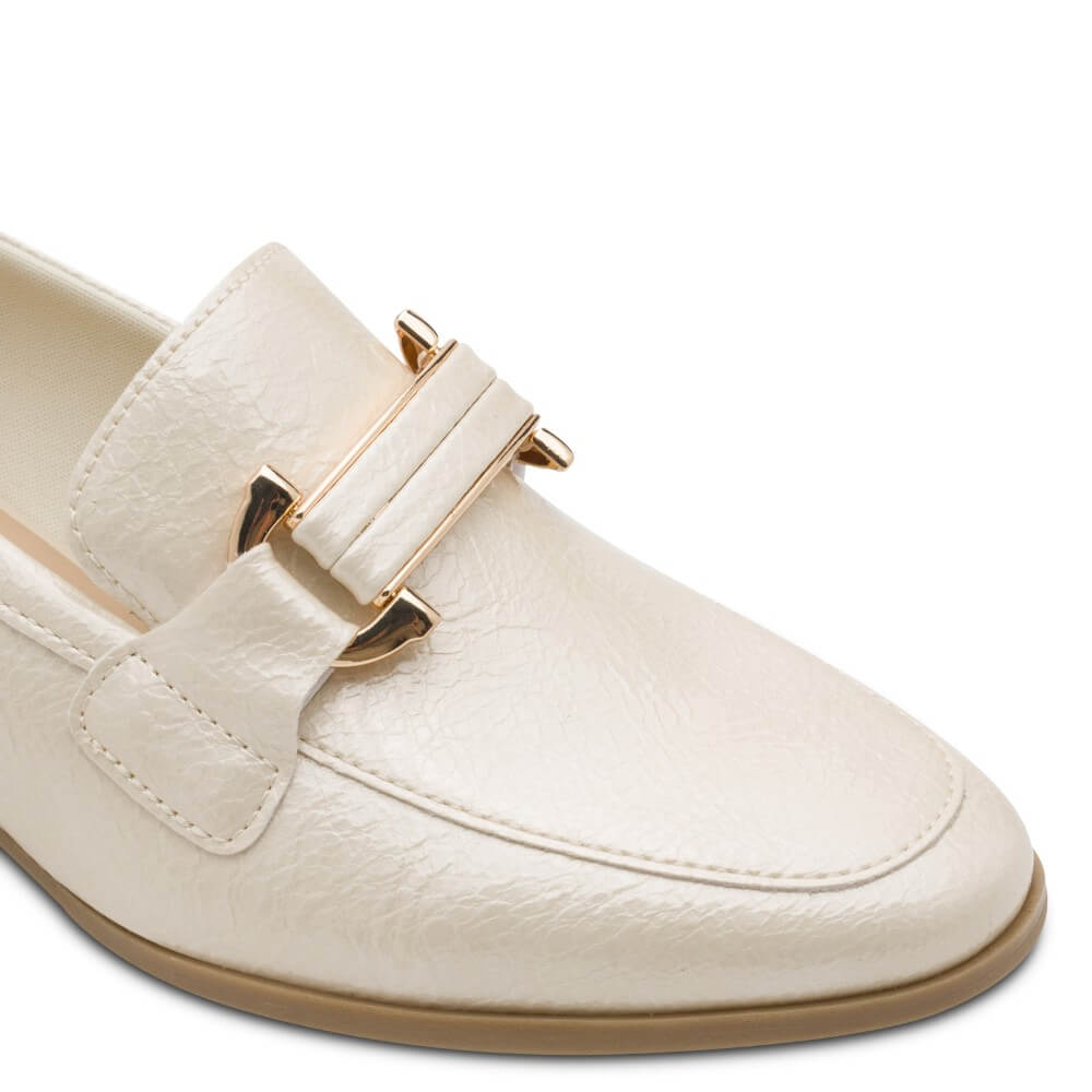 Beige loafer with gold buckle on a white background