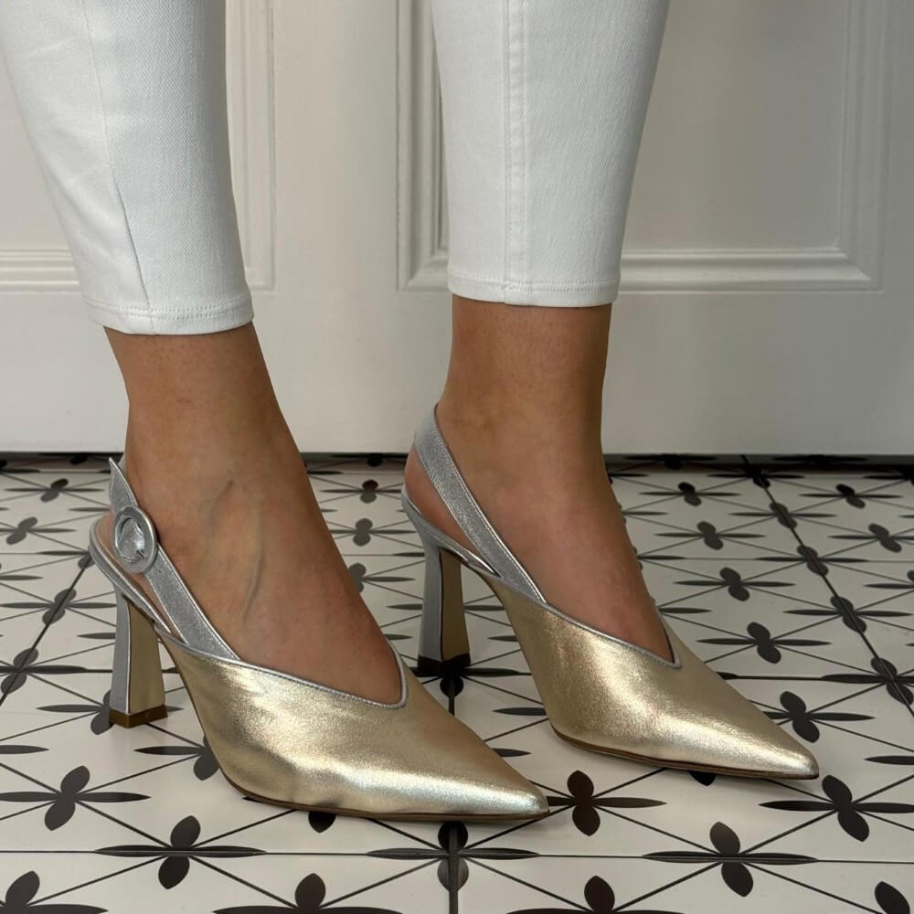 Marian 3406 Gold and Silver high-heeled shoes worn with white pants on a patterned floor.
