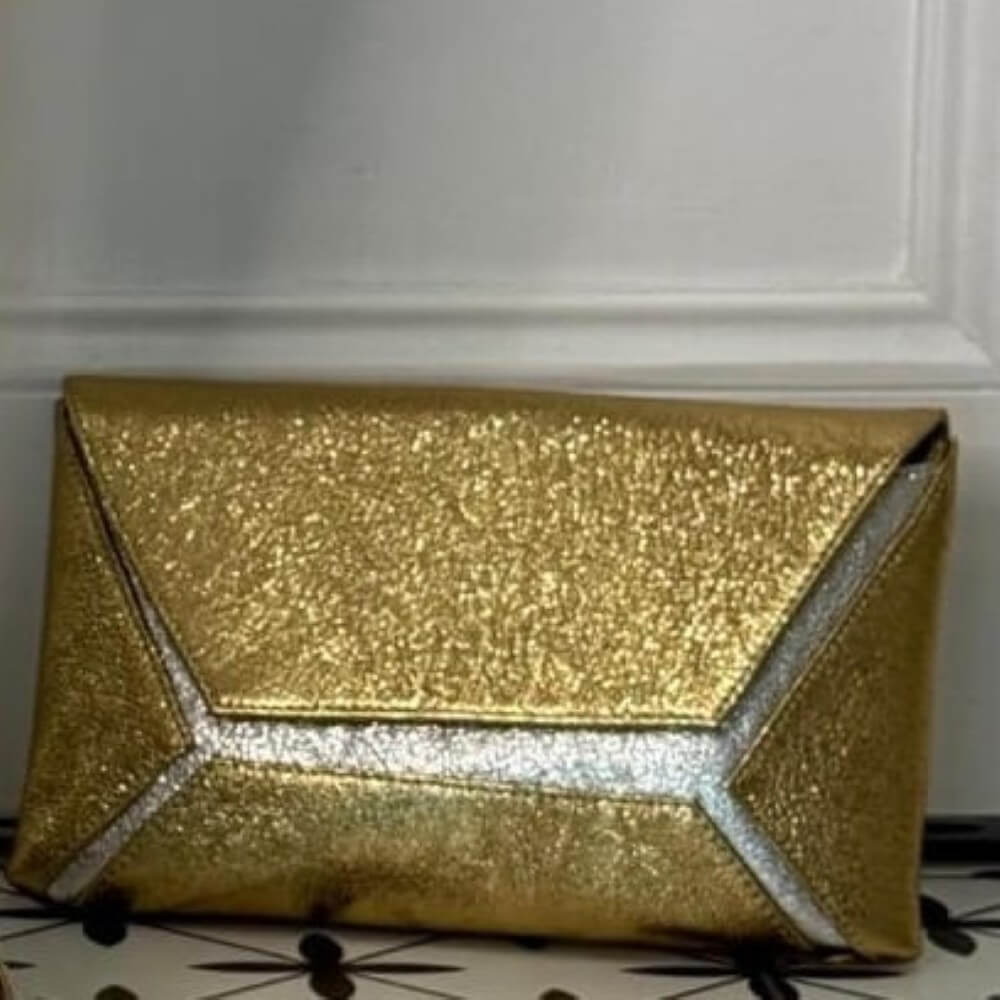 Gold glittery clutch bag on a white background