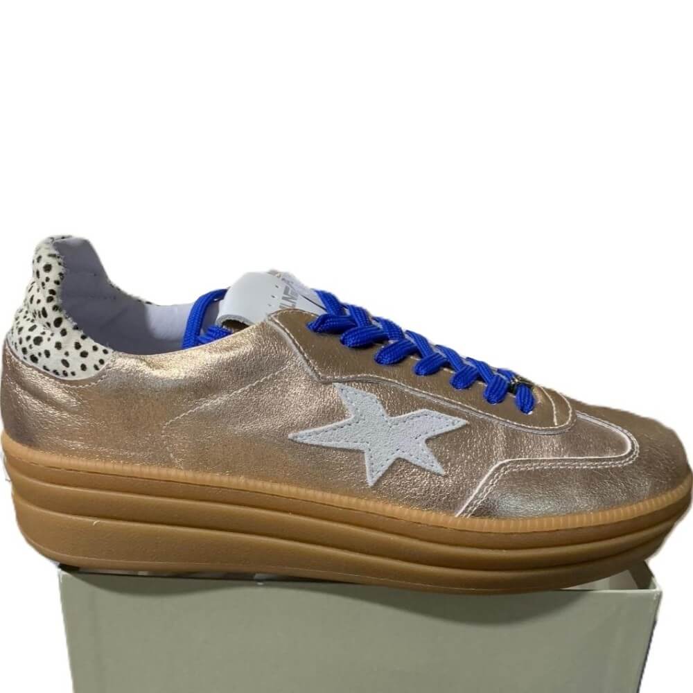 Gold sneaker with blue laces and a white star on a white background Meline Retro 525 Z-GOLD