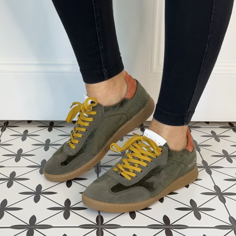 Person wearing green sneakers with yellow laces Meline Retro 526 Green
