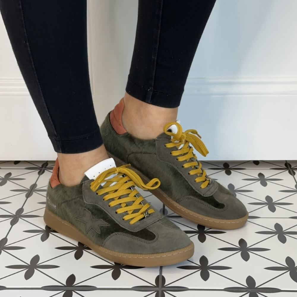 Person wearing green sneakers with yellow laces Meline Retro 526 Green