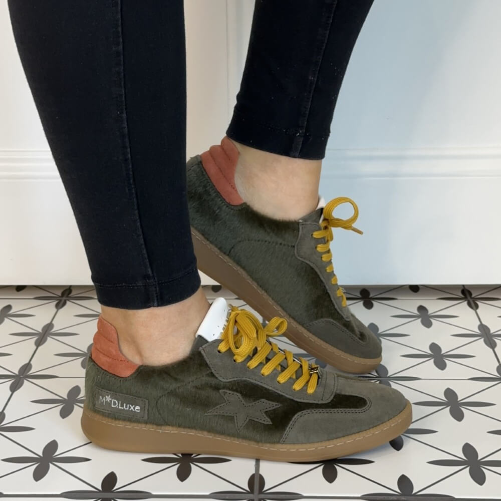Person wearing green sneakers with yellow laces Meline Retro 526 Green