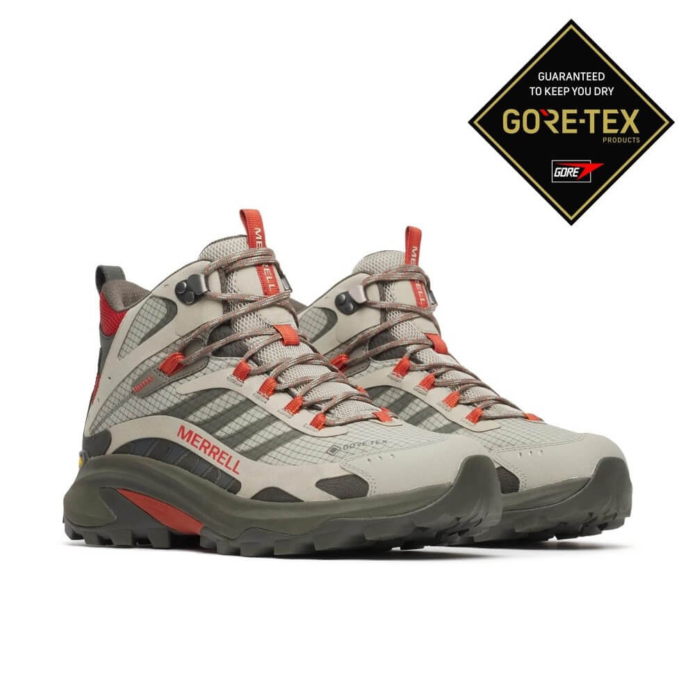 A pair of Merrell mid-height hiking boots in light gray and dark gray with orange-red accents, shown on a white background with a black and gold Gore-Tex logo badge in the top right corner.