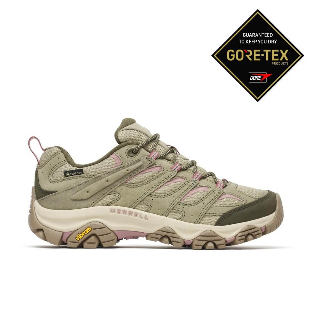 A single Merrell hiking shoe in olive green and beige with light pink accents, shown in profile against a white background. A GORE-TEX guarantee badge is in the top right corner.