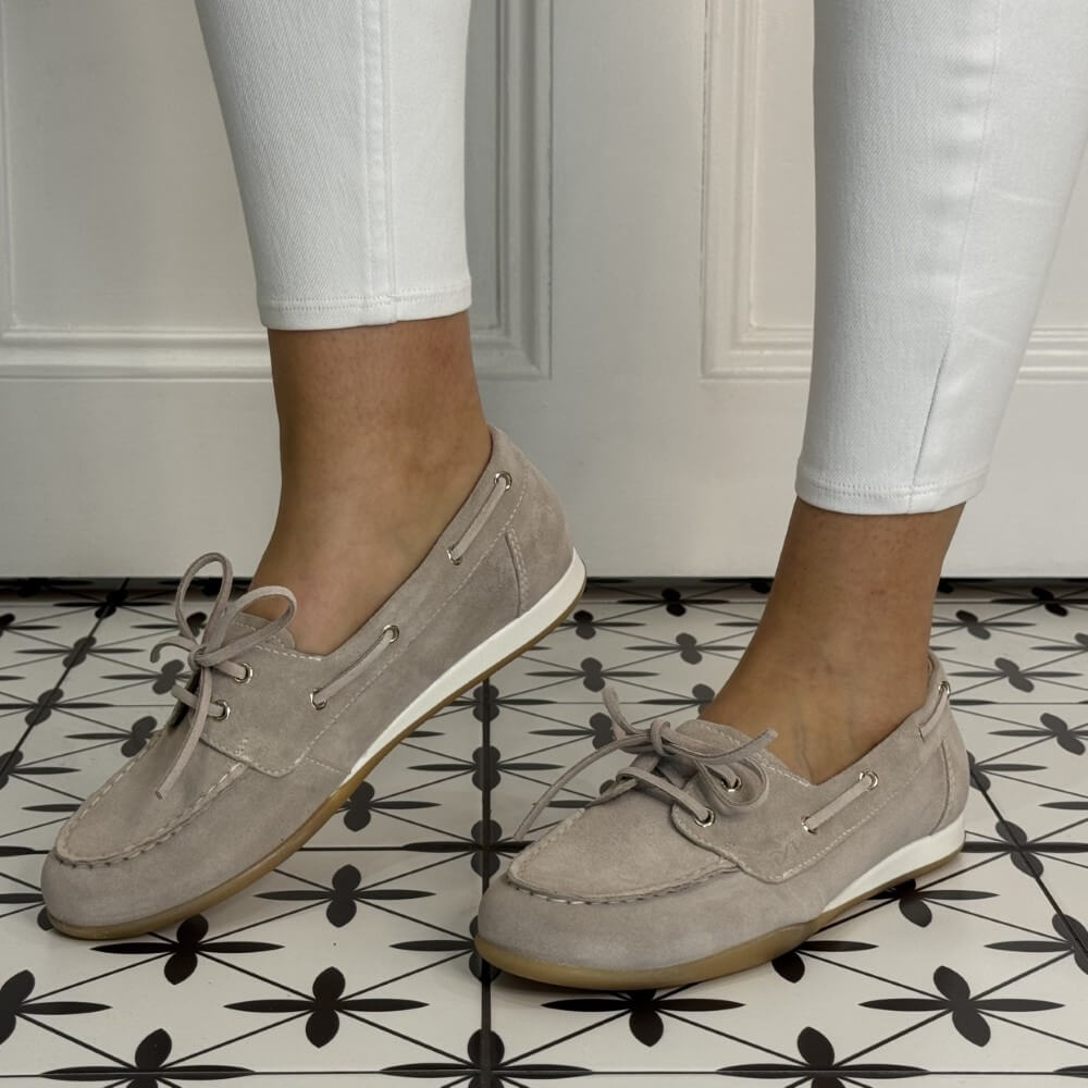 Beige Suede Boat shoes worn with white pants on a patterned floor. E615042D