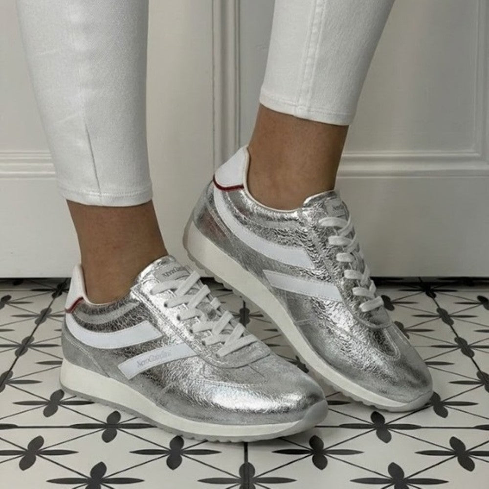 Silver sneakers with white accents worn indoors on a patterned floor. NeroGiardini E615163D