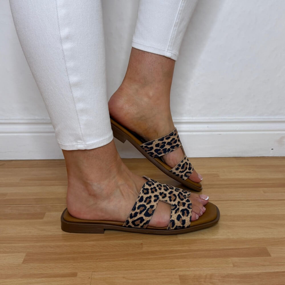 Oh My Sandals 5580 Leopard print sandals worn with white pants on a wooden floor.